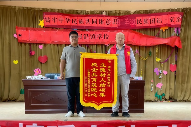 图为学校为风电场赠送锦旗